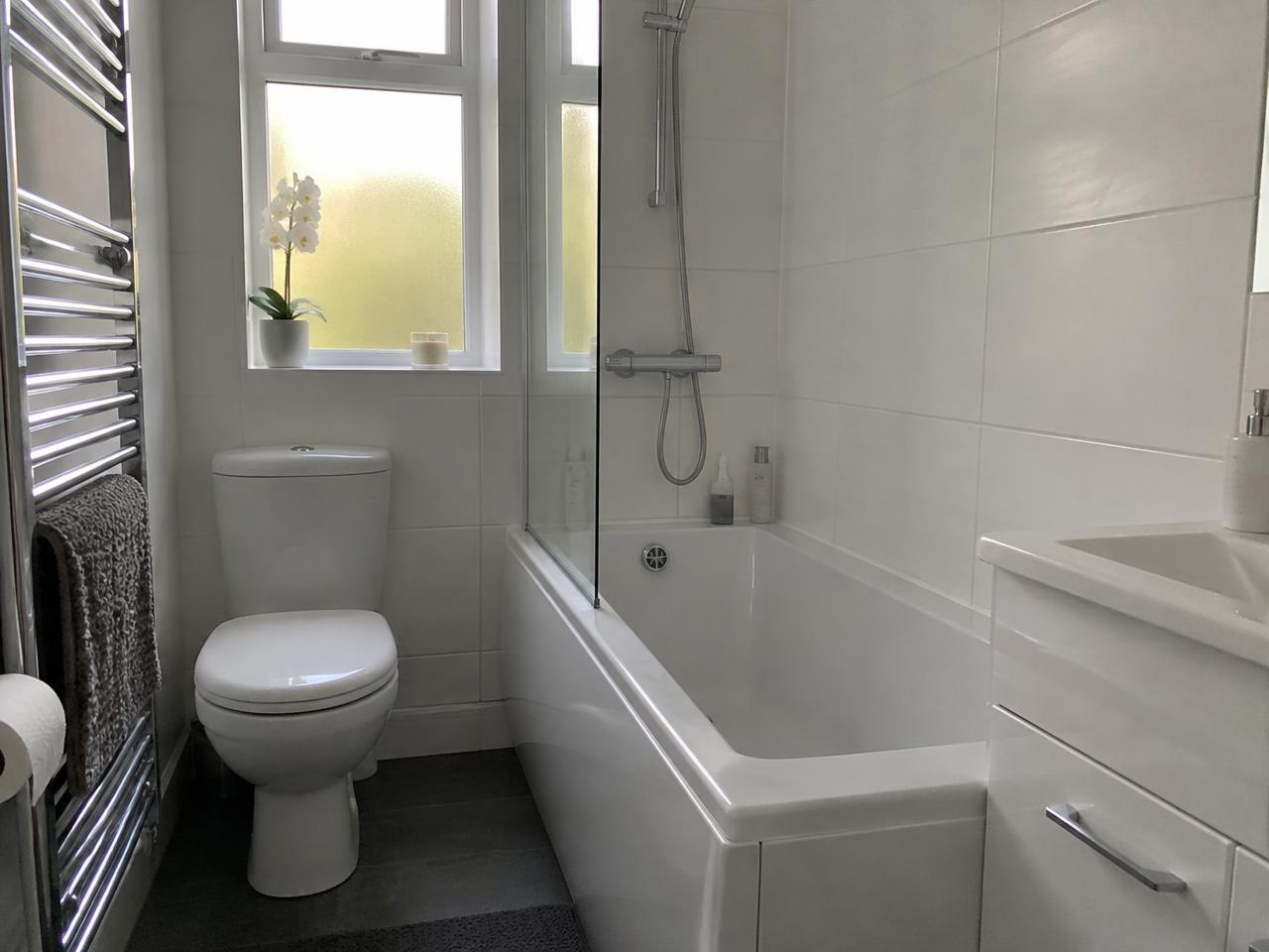 Spotless white marble bathroom with freestanding bath